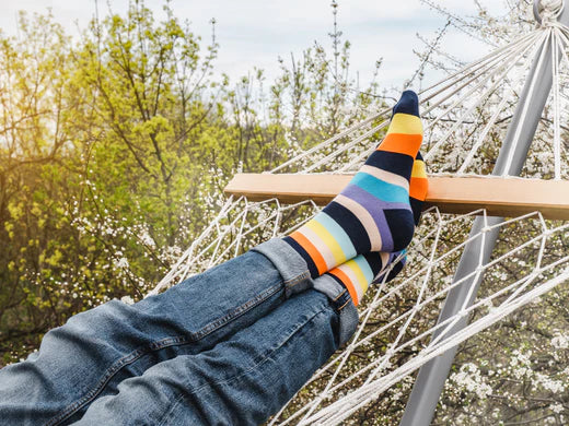 jambe et chaussettes multicolores dans un hamac de cordes de coton avec support métalique