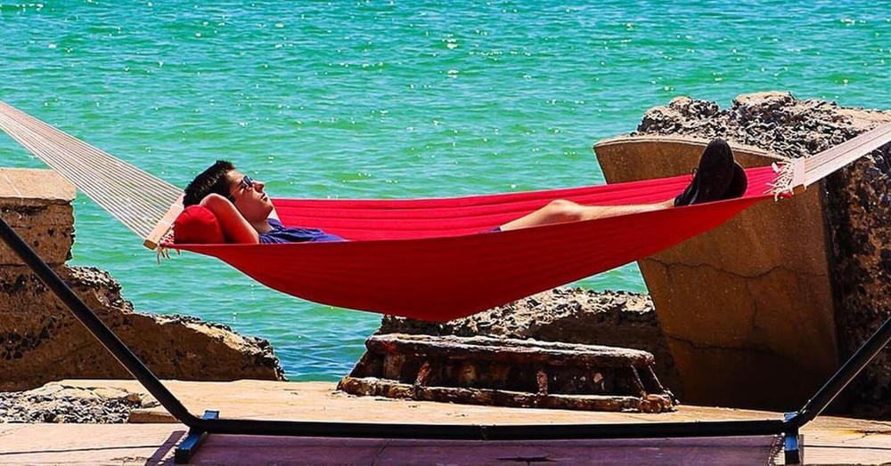 jeune homme dans un hamac au bord de plage