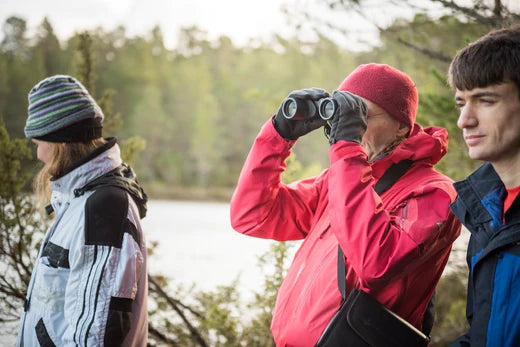 jeunes adultes avec jumelles observant les oiseaux